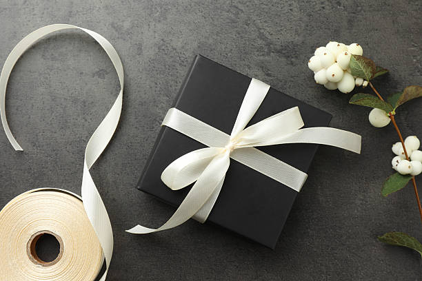 istock Gift box with bow, ribbon and flowers on grey table, flat lay 2224076573