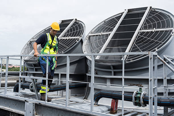 istock Cooling tower operations, Legionnaires disease prevention.
Engineer or technicians maintenance and repair of cooling towers for preventing issues Legionella growth on rooftop of building 2224078022
