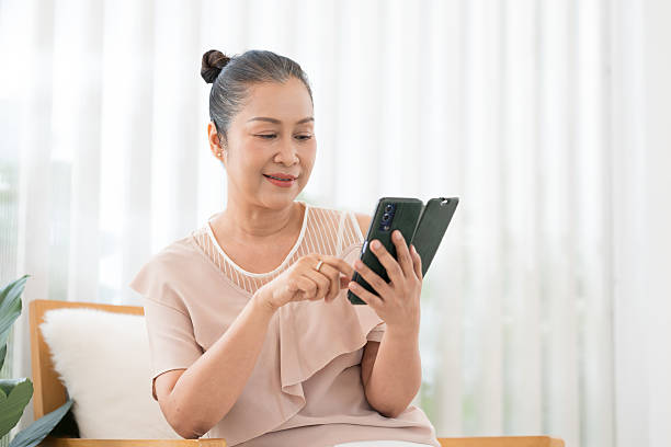istock Asian elderly woman happy and smile while using smartphones at home, typing texting messaging on smartphone. Senior woman use cellphone, chatting online message and shopping online from home 2224080430