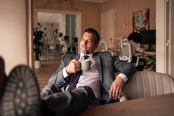 istock Confident Businessman Relaxing With Coffee in Modern Office Environment 2224081628