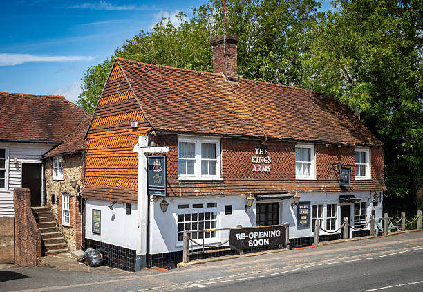 A large sign printed on plastic sheeting reading Re-opening soon attached to the front of a pub in Billingshurst, West Sussex, UK.
