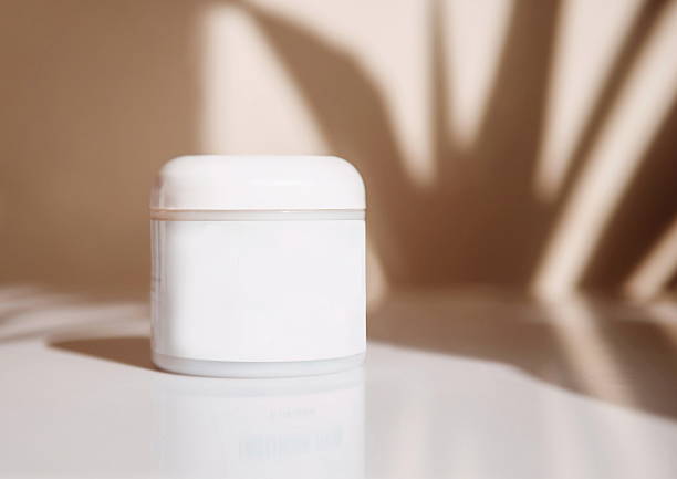 istock Sunscreen Tube with UVA and UVB Protection in jar on white table with sun light and shadow 2224083364