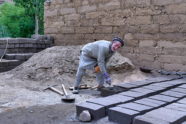 Pakistan worker bricklayer laying bricks in Pakistan in Gilgit. On the outskirts of every town there are old brick factories