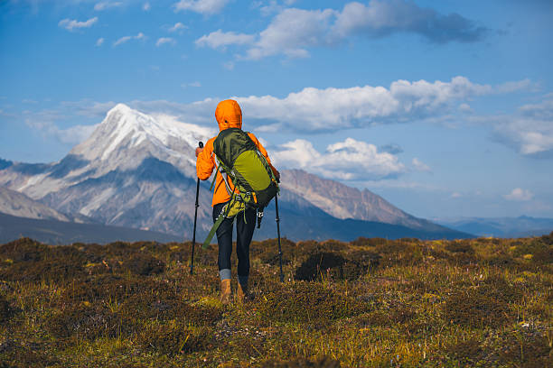 Backpacking woman hiking on sunset high altitude mountain top