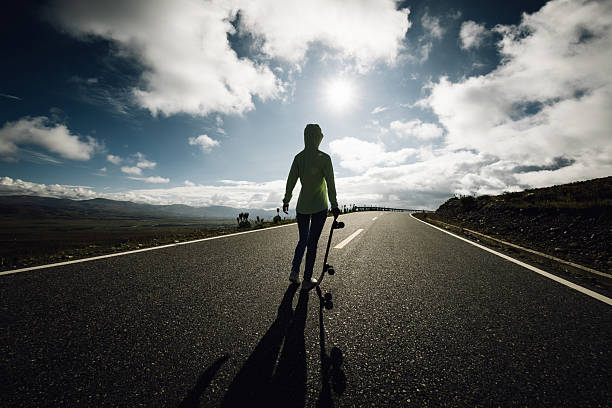 Skateboarder skateboarding on the mountain road