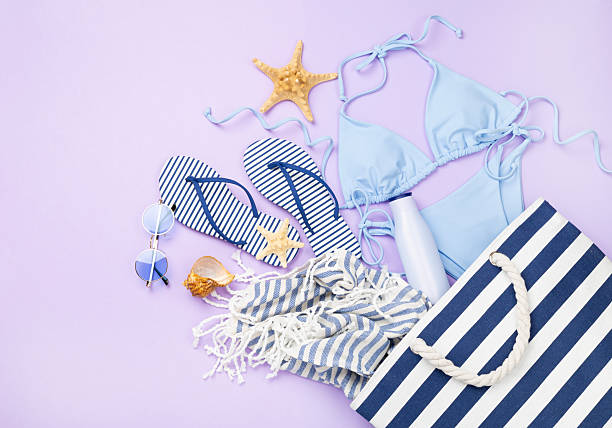 istock Blue bikini with beach accessories on color background, top view 2224089532