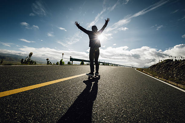 Skateboarder skateboarding on the mountain road