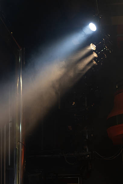 istock spotlight beams illuminates dark space with smoke in the air 2224091860