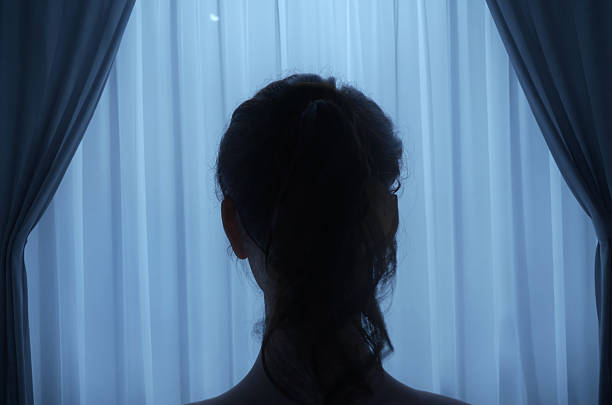 istock back of woman's head behind sheer curtains at night. 3D Rendering 2224092200