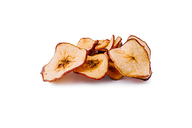 istock Dried apple slices piled on a white surface highlighting their texture and color 2224093509
