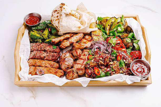 istock Delicious meat platter featuring various grilled dishes served with sauces 2224093531