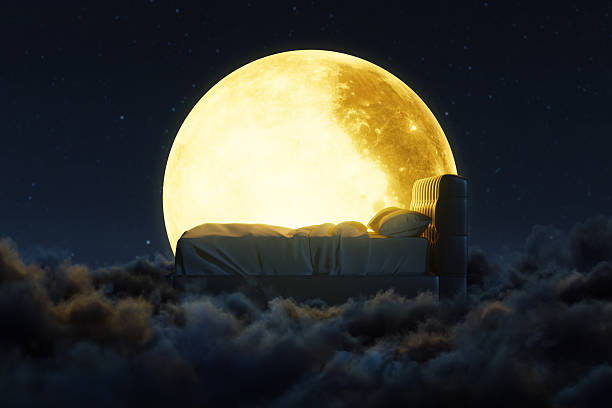 istock 3d rendering of cozy bed over fluffy clouds at night. Lit by the full moon 2224096142