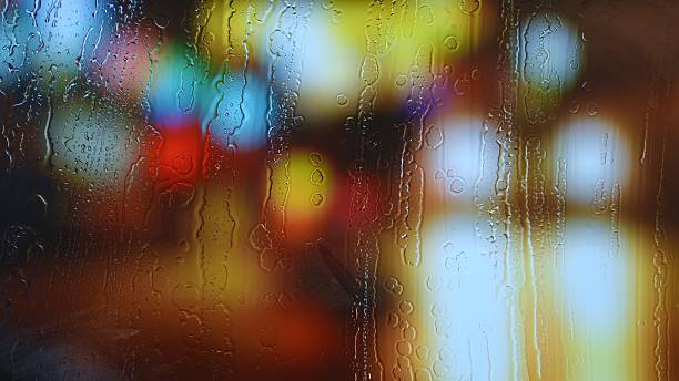 istock Colorful city lights through rainy window glass 2224098121