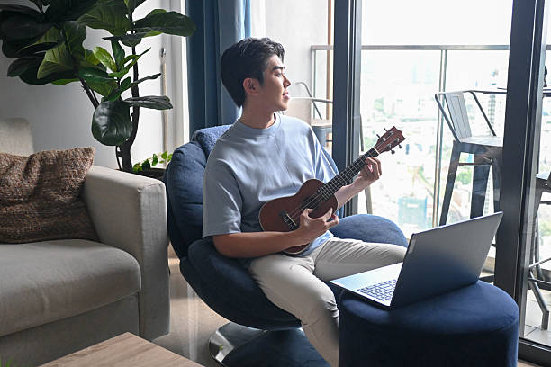 Melodic Moments: Young Man Strums Ukulele at Home