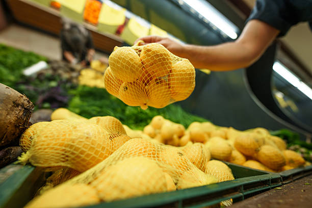 Underside shot of a stack of lemons neatly displayed on the market counter