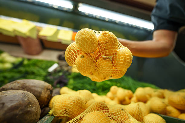 Lemons in a mesh on white background, raw fruit