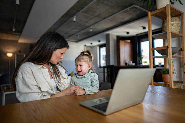 istock Mother comforting crying daughter while working from home 2224101220