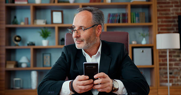 istock Attractive thoughtful successful bearded businessman typing texting message on phone during his work in modern office 2224105228