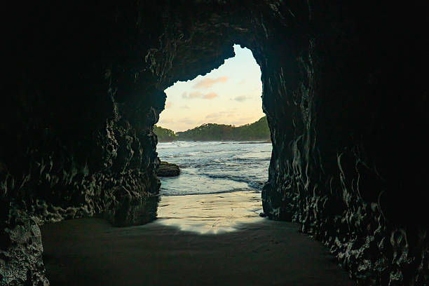 Sea cave opens to the ocean and distant land.