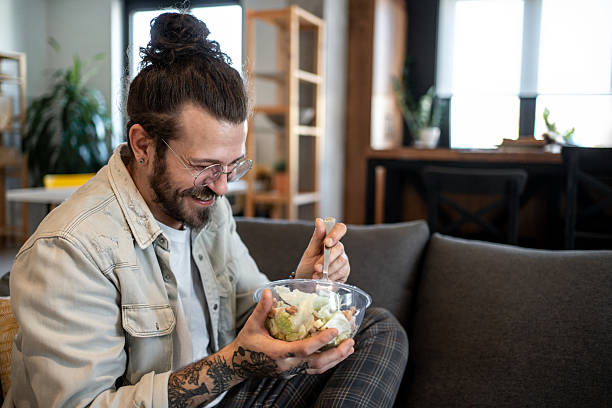 istock Smiling freelancer enjoying a healthy salad during work break at home 2224108975