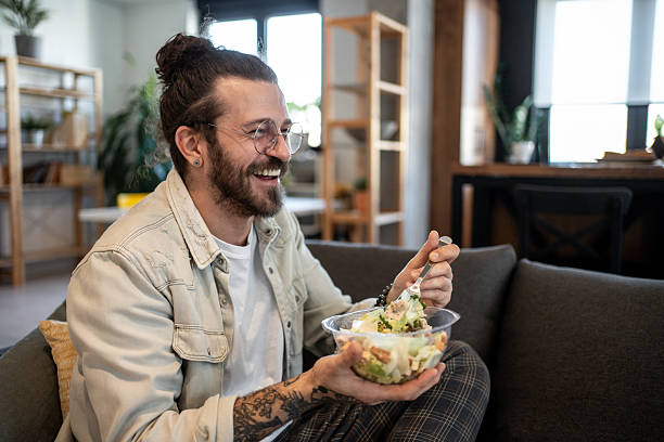 istock Happy freelancer eating a salad at home during his break 2224108976