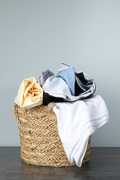 istock Wicker basket full of laundry on table against grey background 2224109293