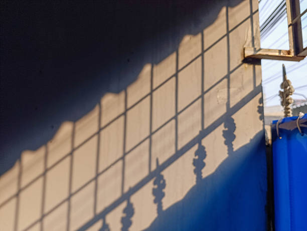 istock Abstract shadow pattern on a construction net fence with strong geometric lines and bold blue background. Taken in Jakarta, Indonesia, this image highlights urban shapes and light interaction. 2224109322