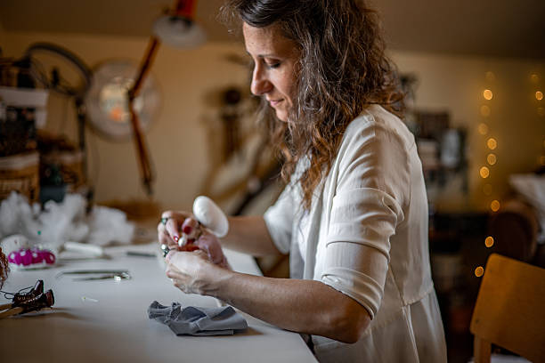 istock Female maker and doll artist creating whimsical fabric dolls in her handmade studio, tailoring each item with care for boutique customers 2224109569