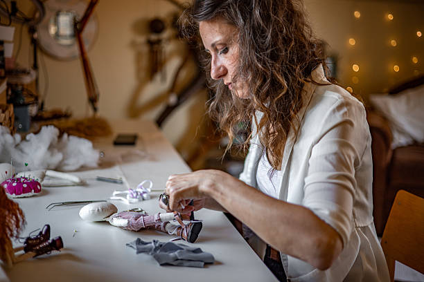 istock Independent designer passionately handcrafting unique fabric characters in a snug home-based workspace, building her creative brand through personalized toy orders 2224109596