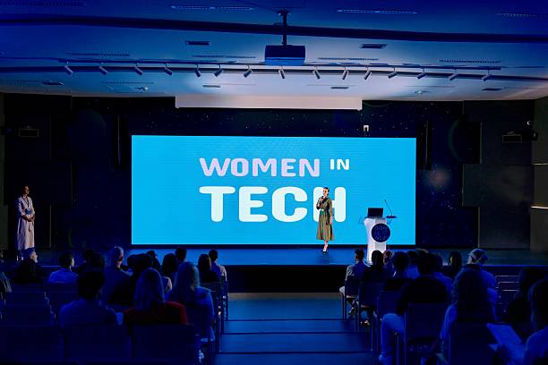 istock Moderator presenting Speaker at a Women in Technology Conference in Modern Hall 2224110613