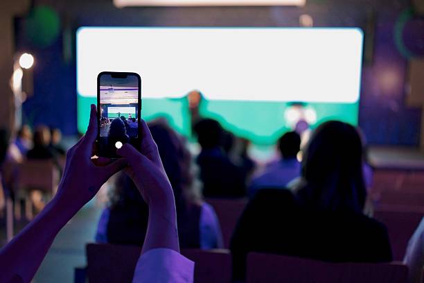 istock Person Recording a Live Technology Event Inside a Modern Conference Room 2224110751