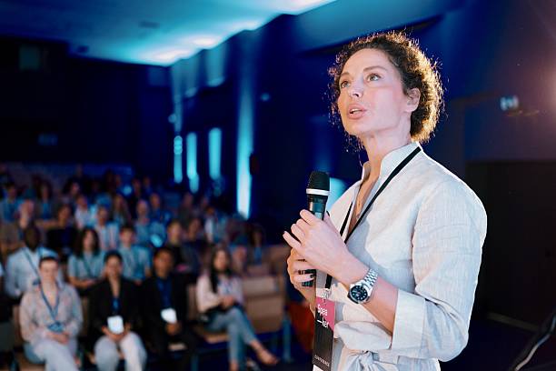 istock Confident Speaker Presenting To Engaged Audience at Professional Conference Hall 2224110842