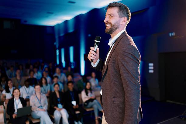istock Man Delivering Presentation at Technology Conference to an Engaged Audience 2224110869