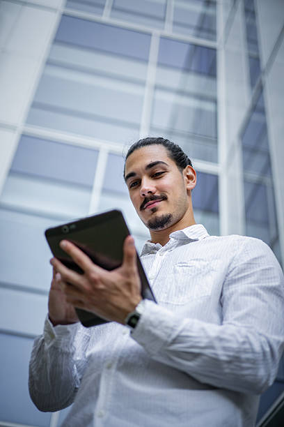 istock AI Product Manager reviewing project analytics on a tablet, leading AI innovation outside a cutting-edge modern business headquarters 2224111174