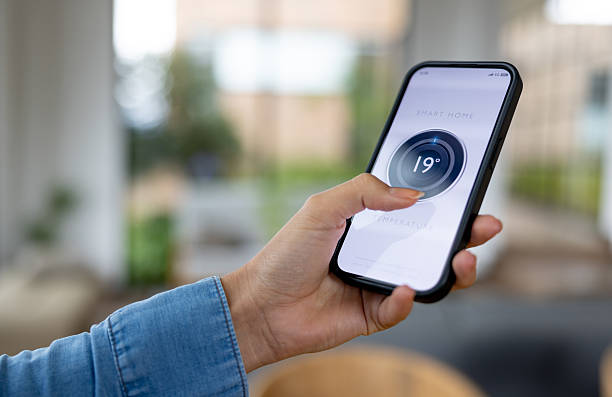 istock Woman controlling the temperature of her smart home using a mobile app 2224111876