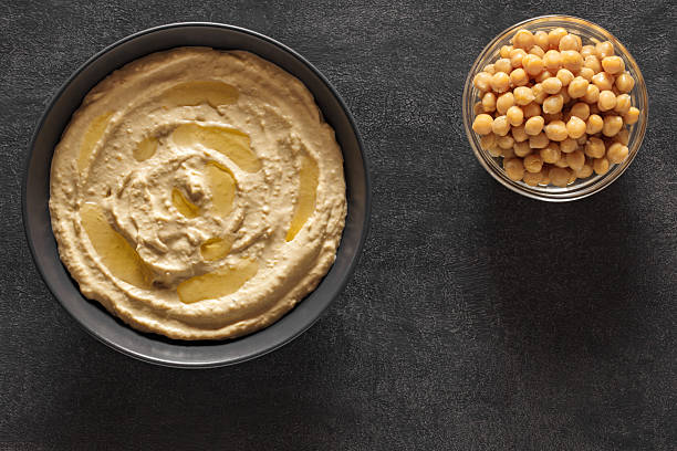 istock hummus with butter and chickpeas in bowls on dark table, top view 2224112276