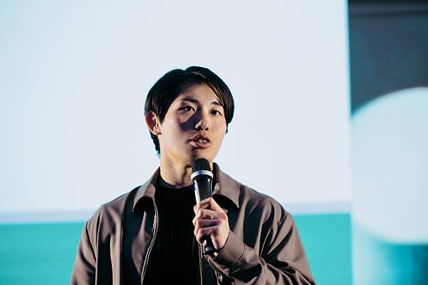 istock Confident Young Speaker Presenting Innovative Ideas at a Modern Tech Conference 2224113006