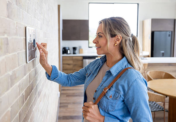 istock Woman leaving her house and locking the door using an automation system 2224116068