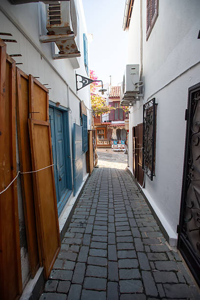 istock A narrow street between two old white houses. 2224117630