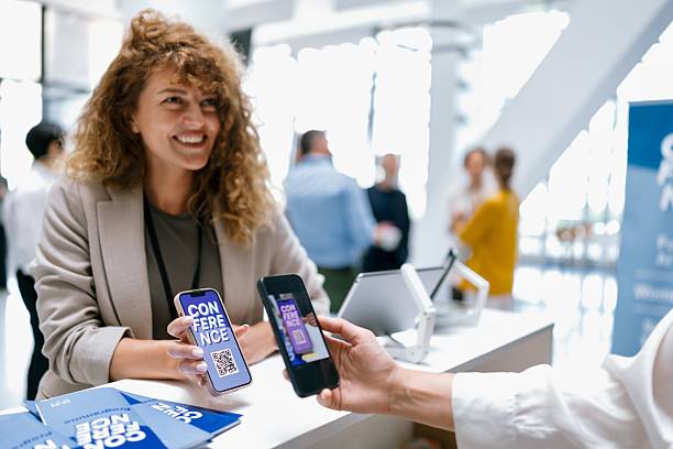 istock Close up of an Attendee checking in at business conference registration desk with QR code 2224118780