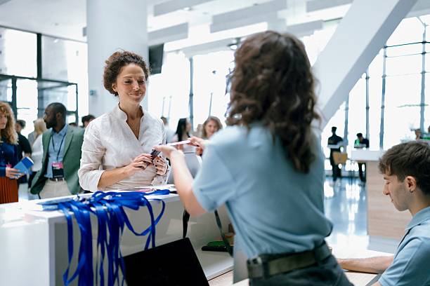 istock Attendees Registering at a Corporate Event Reception Desk with Staff and Badges Displayed 2224118802