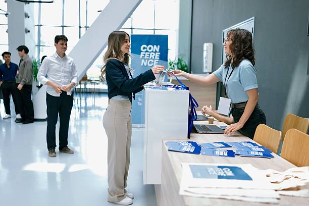 istock Registration at a Corporate Event Desk with Friendly Staff and Technology Usage 2224118837