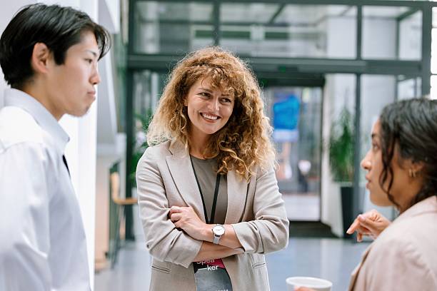 istock Happy business people laughing while interacting with each other during seminar 2224118986