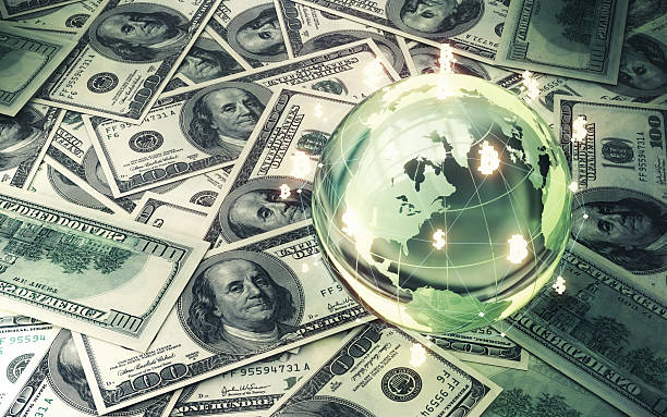 istock Crystal Glass Globe with Bitcoin Dollar and Financial Chart on Stack of 100 Dollar Bills 2224120584