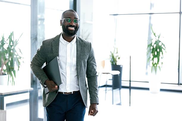 istock Confident businessman holding laptop and looking at camera 2224120798