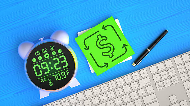 This conceptual flat lay image effectively illustrates the dynamics of Cash Flow and a Circular Economy. A sticky note with a dollar sign inside circular arrows is placed on an office desk with a digital clock, keyboard, and pen. The icon symbolizes the continuous movement of money, including Revenue, Investment, and Return on Investment. This is a powerful visual for topics in Finance and Economy, Business Strategy, and sustainable business models. It represents the ongoing process of Making Money, financial management, and the strategic circulation of capital