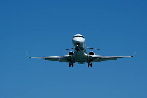 istock Airplane Landing Approach Against Clear Blue Sky 2224125615