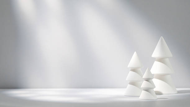 istock Minimalist white Christmas tree sculptures set against a soft grey backdrop illuminated by gentle light 2224126261