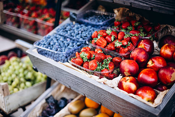 Fresh strawberries, nectarines, and blueberries at an outdoor summer market.