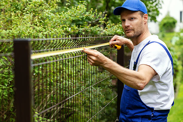 istock fencing services. worker taking measurements with measuring tape 2224129565